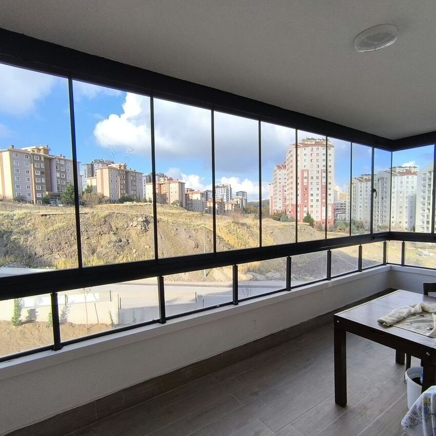 Oturma alanı olarak düzenlenmiş cam balkon